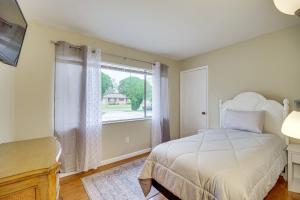 a bedroom with a bed and a large window at Palm Bay Home with Screened Porch - 8 Mi to Beaches! in Palm Bay