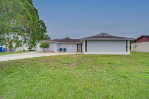 a house with a lawn in front of it at Palm Bay Home with Screened Porch - 8 Mi to Beaches! in Palm Bay