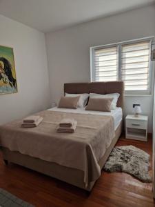 a bedroom with a large bed with two towels on it at Villa JaNi in Donja Jagodnja +28 photos