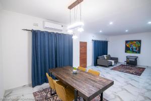 a living room with a wooden table and chairs at White Rhino apartments & tours in Livingstone