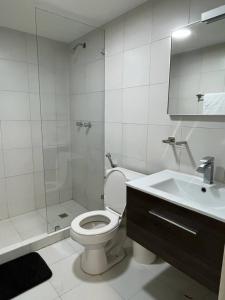 a bathroom with a toilet and a shower and a sink at Brand new apt San Bernardino Caracas in Caracas