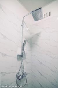 een douche met een douchekop in de badkamer bij White Rhino apartments & tours in Livingstone