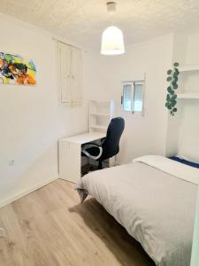 a bedroom with a bed and a desk and a chair at Apartamentos Aldai Valencia in Aldaia