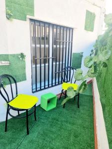 a balcony with two chairs and a table and a window at Apartamentos Aldai Valencia in Aldaia