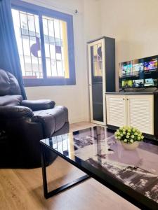 a living room with a glass coffee table and a chair at Apartamentos Aldai Valencia in Aldaia
