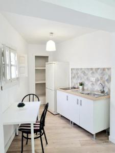 una cocina con electrodomésticos blancos, mesa y sillas en Apartamentos Aldai Valencia en Aldaia