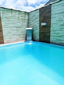 una piscina con una fuente de agua en Suncoast House, en Cabo Frío