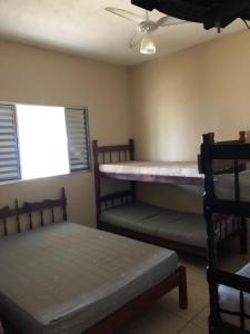 Zimmer mit 2 Etagenbetten und einem Deckenventilator. in der Unterkunft Apartamentos Ilha Comprida in Ilha Comprida