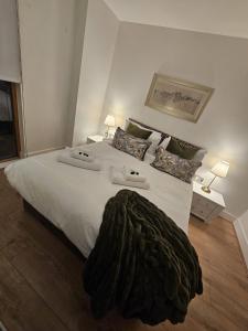 Luxury Property in Canary Wharf في لندن: غرفة نوم بسرير كبير عليها شراشف ووسائد بيضاء