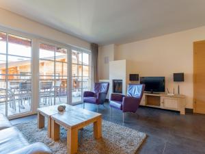 a living room with a couch and chairs and a tv at Mountainview in Kaprun