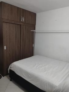 1 dormitorio con 1 cama y armario de madera en Welcome to Medellin in our home, en Medellín