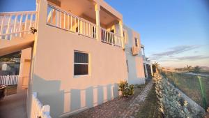 a white building with a fence next to it at Lulu cottage in Basse Terre Town