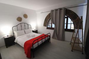a bedroom with a bed with a red blanket at Casas da Biquinha in Sintra