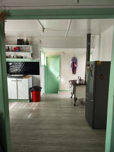 a kitchen with a green door and a refrigerator at Magic Hause Patagonia in Puerto Natales