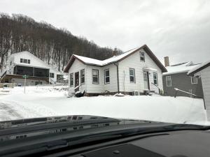 a house with snow on the top of a car at The Great River Retreat in New Albin