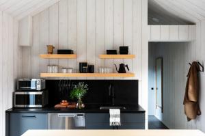 a kitchen with a black counter and a microwave at Tälta Lodge, a Bluebird by Lark in Stowe