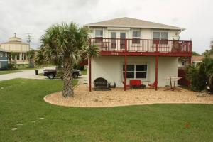 a house with a balcony and a palm tree at Beach, Oceanfront, Flagler Beach Rental in Flagler Beach