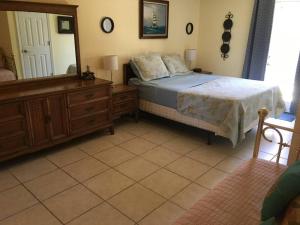 a bedroom with a bed and a dresser and a mirror at Beach, Oceanfront, Flagler Beach Rental in Flagler Beach