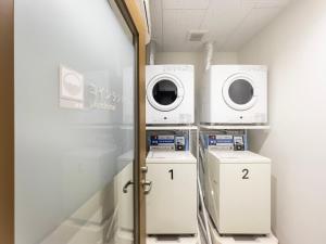 - une buanderie avec 2 lave-linge et sèche-linge dans l'établissement Super Hotel Yamaguchi Yuda Onsen, à Yamaguchi