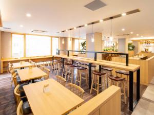 a restaurant with wooden tables and chairs and a bar at Super Hotel Yamaguchi Yuda Onsen in Yamaguchi