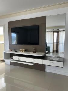 sala de estar amplia con TV en la pared en Apartamento com vista mar, en Porto Belo