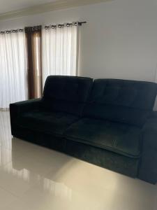 un sofá negro sentado en una sala de estar en Apartamento com vista mar, en Porto Belo 7 fotos más