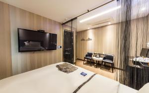 een hotelkamer met een bed en een flatscreen-tv bij W hotel in Incheon