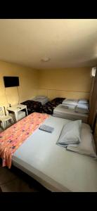 1 dormitorio con 2 camas y TV de pantalla plana en Pousada caminho das praias jp, en João Pessoa