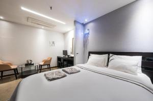 a bedroom with a large white bed and a desk at W hotel in Incheon