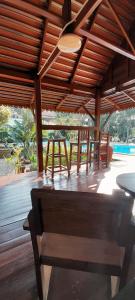 a wooden patio with a bench under a wooden roof at Pasak River House 