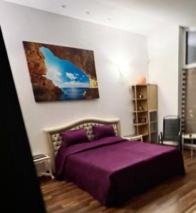 a bedroom with a purple bed with a purple blanket at CENTRO Guest House in Alytus