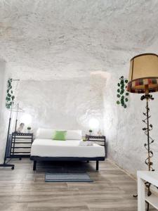 a white room with a bed and a lamp at Apartamento Cueva La Torre in Aldaia