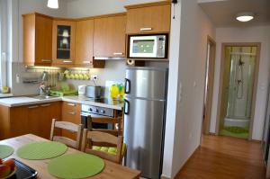 シオーフォクにあるSunset Beach Apartmentのキッチン(ステンレス製の冷蔵庫、テーブル付)