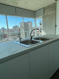 um balcão de cozinha com um lavatório e uma janela em Brand new apt San Bernardino Caracas em Caracas