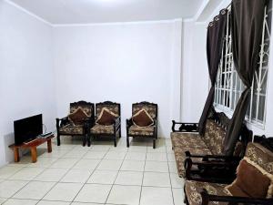 a room with three chairs and a couch and a tv at Departamento amoblado excelente para familias in Puerto Baquerizo Moreno