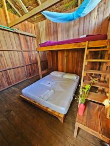 an empty room with a bed in a wooden cabin at Hakuna Matata Ecolodge in El Valle