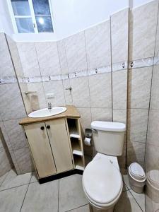 łazienka z toaletą i umywalką w obiekcie Departamento amoblado excelente para familias w mieście Puerto Baquerizo Moreno
