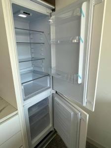 an empty refrigerator with its door open in a kitchen at Brand new apt San Bernardino Caracas in Caracas