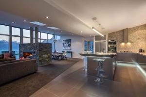 eine Küche und ein Wohnzimmer mit einem Kamin in der Unterkunft Villa Matau- Gas Fire- Lake Views- AC- BBQ in Queenstown