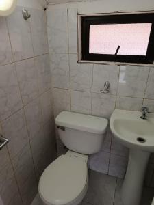 a bathroom with a white toilet and a sink at Cómoda Casa en sector residencial Osorno in Osorno