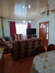 Cómoda Casa en sector residencial Osorno في أوسورنو: غرفة معيشة مع أريكة وتلفزيون بشاشة مسطحة