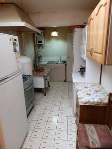 a small kitchen with a refrigerator and a sink at Cómoda Casa en sector residencial Osorno in Osorno