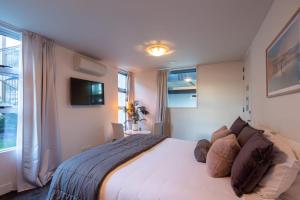 sypialnia z łóżkiem i telewizorem na ścianie w obiekcie Villa Mantra- Free Parking- AC- Direct Lake Access w mieście Queenstown