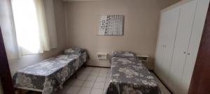 a room with two beds and a window at Pousada Palmeira in Viracopos