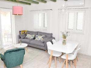 Una sala de estar con un sofá, una mesa y sillas. en Seaside apartments with a swimming pool Razanac, Zadar - 22306, en Ražanac