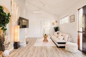 sala de estar con sofá blanco y TV en An Idyllic Boho Style Retreat High-end kitchenware en Gold Coast