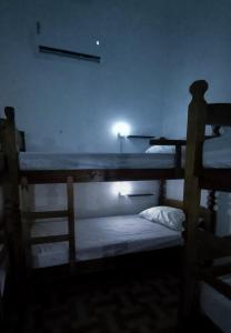 two bunk beds in a dark room with a light at Yolo Hostel in João Pessoa