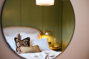 a bedroom with green walls and a bed with pillows at Ty Afon - River House in Beddgelert