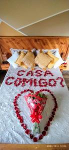 un corazón hecho de rosas en una cama en PENEDO ACONCHEGO LOFT: VISTA, CONFORTO E NATUREZA! en Penedo