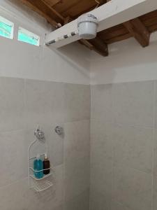 uma casa de banho com um chuveiro e uma garrafa azul em La Casita Colonial em Venecia